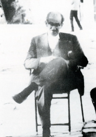 Ενας κύριος με γυαλιά κάθεται σε κάρεκλα